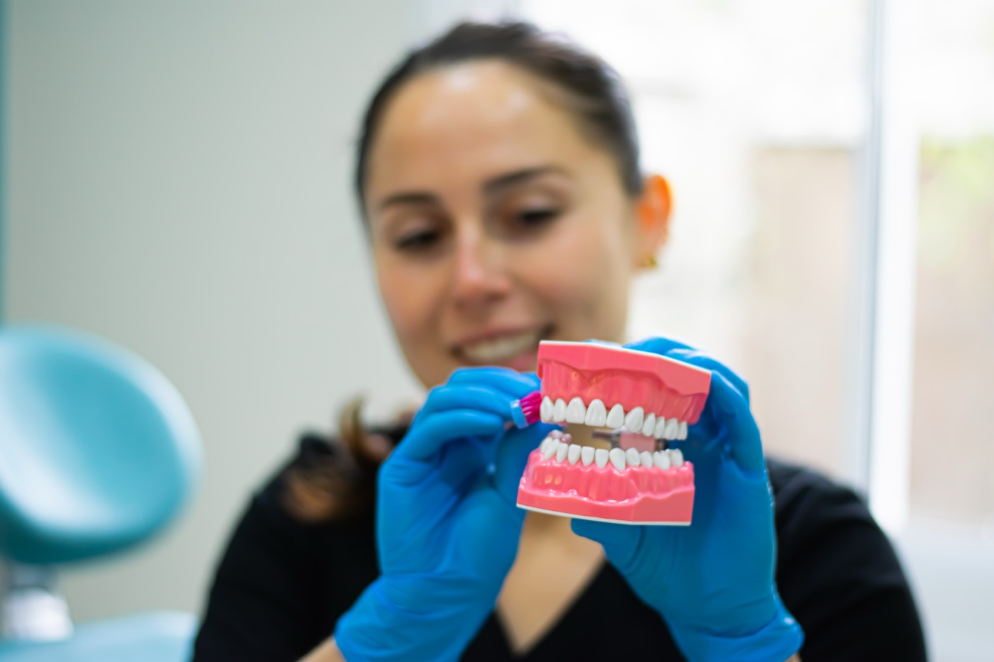 Profesional mostrando la técnica de higiene con un modelo dental